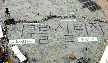 Environmental activists make the words 'save the earth' using solar panels.