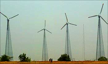Rajasthani women pass windmills near Jaisalmer.