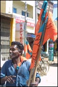 A BJP worker putting up his party's flags