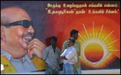 Subdued DMK workers before a poster of their leader