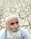 A Sikh farmer sits on his dry rice paddy in Punjab 