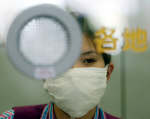 An airline ticket counter staff wears a mask to protect herself from the deadly flu-like SARS virus at Beijing Airport. Reuters/Wilson Chu