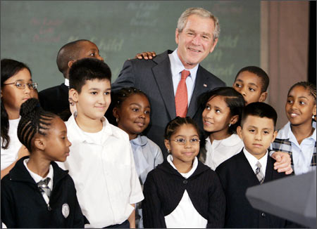 Former US President George W Bush poses with children from Public School 76 in New York City after giving a progress report on his Administration's No Child Left Behind programme