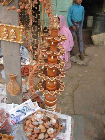 Earthen lamps on display at a roadside stall.