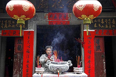 A resident burns incense as he prays in a small temple in the village of Wukan in Lufeng county, Guangdong province.