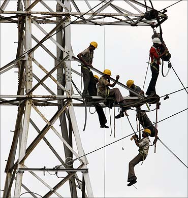 Linemen set up high tension power lines on the outskirts of Ahmedabad.