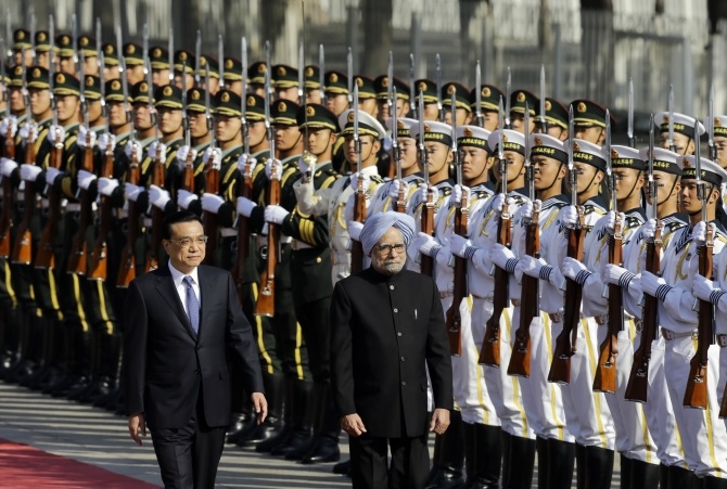 Prime Minister Manmohan Singh inspects a guard of honour with China's Premier Li Keqiang during a welcome ceremony outside the Great Hall of the People in Beijing