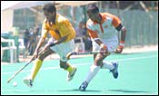 Indian Airlines defender Dilip Tirker (white) tires to stop Tata's Shivendra Singh.