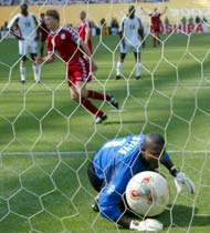 Denmark's Jon Dahl Tomasson beats Senegal's goalkeeper Tony Sylva from the penalty.