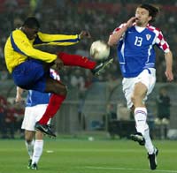 Ecuador's Carlos Tenorio (L) and Croatia's Mario Stanic jump for the ball.