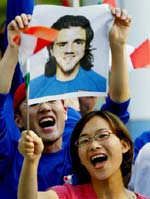 South Korean fans wave Italian flags and a picture of Italy's player Gennaro Gattuso as they await the arrival of the Italian team on Sunday.
