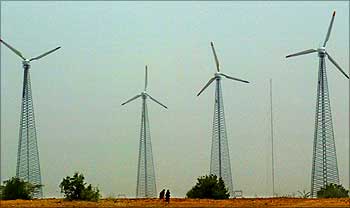 Rajasthani women pass windmills near Jaisalmer.