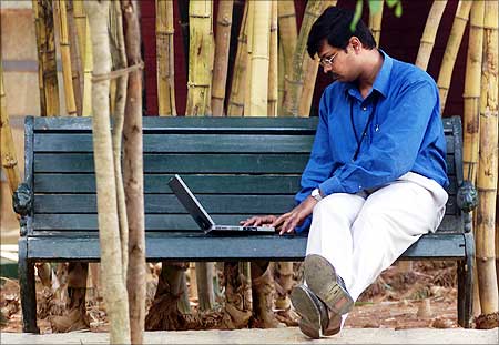 An employee of Infosys Technologies Ltd works on a laptop during lunch break in Bangalore.