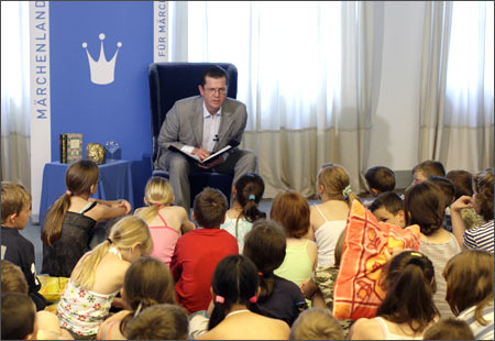 German Economy and Technology Minister Karl-Theodor zu Guttenberg reads a fairy tale to school children in Berlin, July 2, 2009.