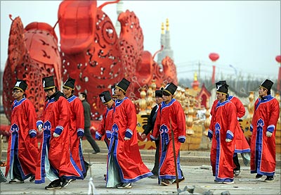 Staff dressed in traditional Chinese costumes walk past lanterns set up for the first China Intangible Cultural Heritage Park Lantern Art Festival in Hefei.