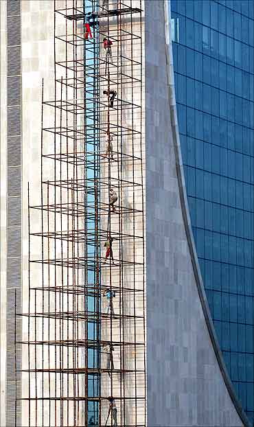 Men work at the construction site of a high-rise commercial building in New Delhi.