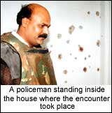 A policeman standing inside the house where the encounter took place 