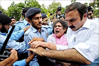 Pakistani policemen arrest Nawaz Sharif's supporters during a clash in Islamabad, September 10. Baton-wielding police clashed with around Sharif's supporters and arrested key members of his party as he returned, while security forces threw up a five-kilometre security cordon around Islamabad airport.
