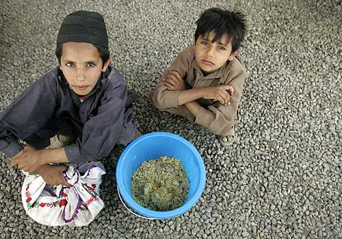 Children sit with their ration of rice at the Yar Hussain camp.