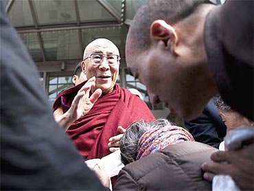 The Dalai Lama greets supporters outside of his hotel