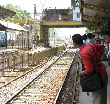 Commuters wait for a train at Dadar station in Mumbai.