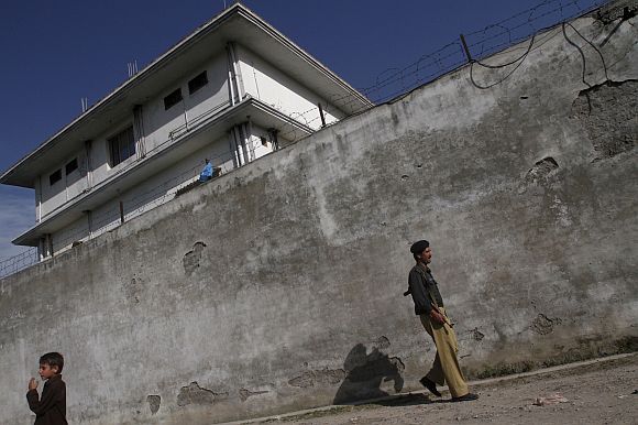 Pakistani security personnel walk past the compound in Abbottabad where Osama bin Laden was killed by US Special Forces