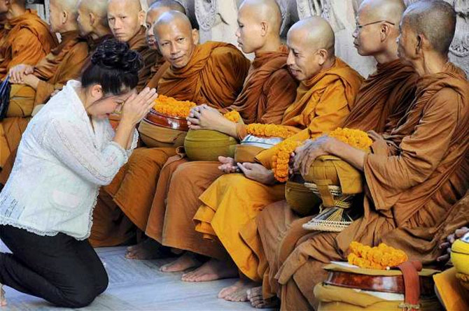 A Thai devotee seeks blessings of Buddhist monks at Mahabodhi temple in Bodh Gaya.