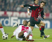 Hatem Trabelsi of Ajax (L) fights for the ball with Filippo Inzaghi of AC Milan (R)