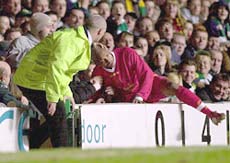 El Hadji Diouf is patted on the head as he falls into Celtic supporters 