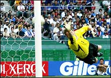 Belgium goalkeeper Geert de Vlieger watches the ball sail into the net from a free-kick taken by Raouf Bouzaiene. 