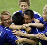 Japan's Hiroaki Morishima is mobbed by team mates after scoring. 