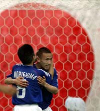 Hidetoshi Nakata is hugged by team mate Hiroaki Morishima (L) after scoring Japan's second goal.